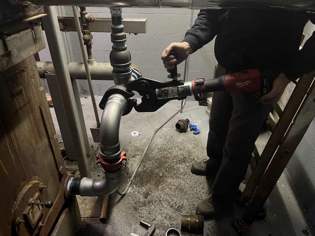 Technician working on overhead steam piping